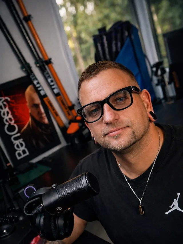 Benjamin O. Giese an seinem Arbeitsplatz, vor ihm ein Mikrofon